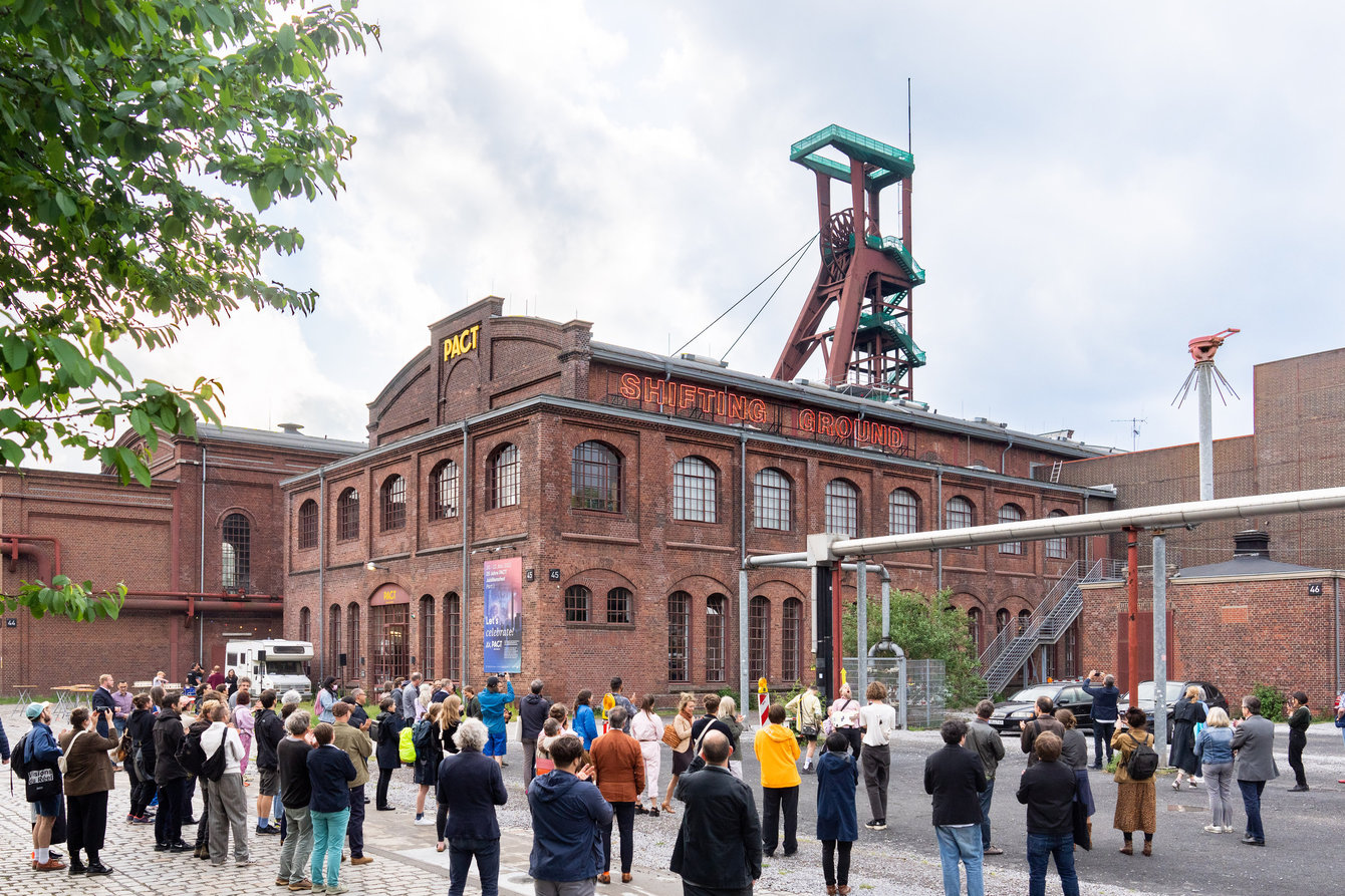 Hausansicht PACT Zollverein mit vielen Menschen, die vor dem Haus stehen