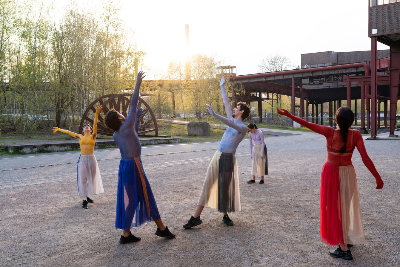 Gruppe von Tänzer:innen in der Abendsonne auf dem Zollverein-Gelände