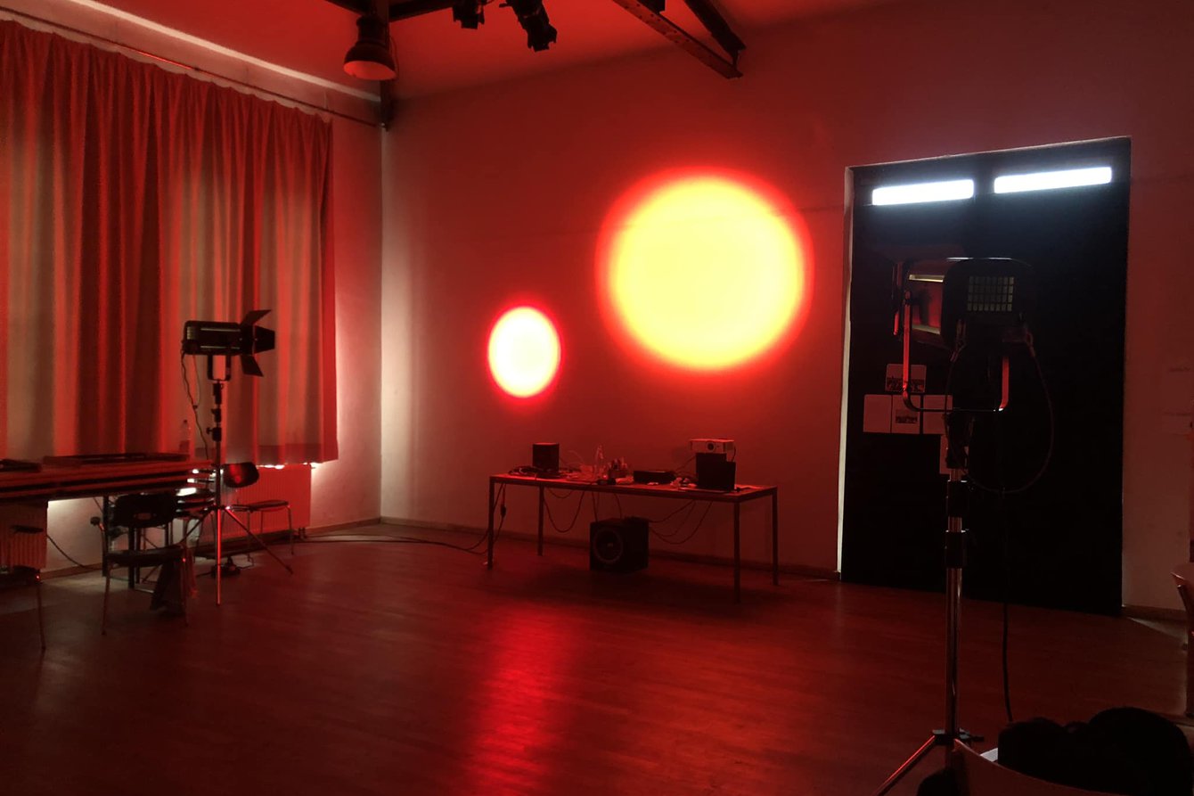 Studio set up at PACT: Two red lights reflected on a wall