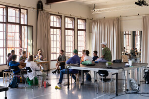 Eine Gruppe von Menschen sitzt in einem Studio bei PACT Zollverein